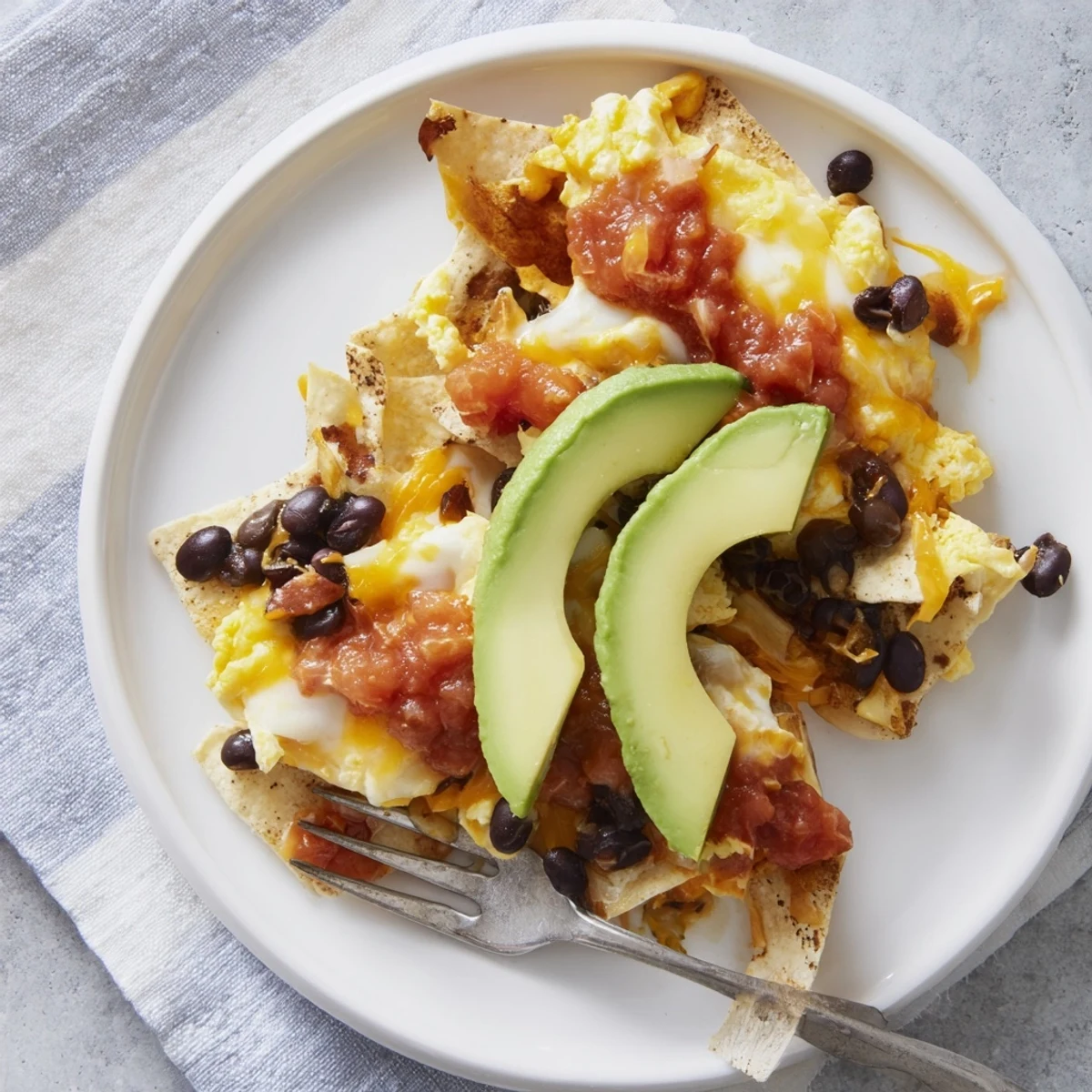 Cheesy loaded breakfast nachos baked to perfection with eggs and black beans.
