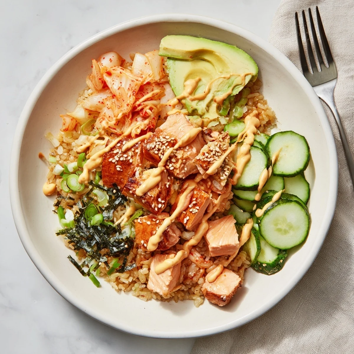 Crispy Salmon Rice Bowl topped with vibrant avocado, kimchi, and spicy mayo drizzle.  