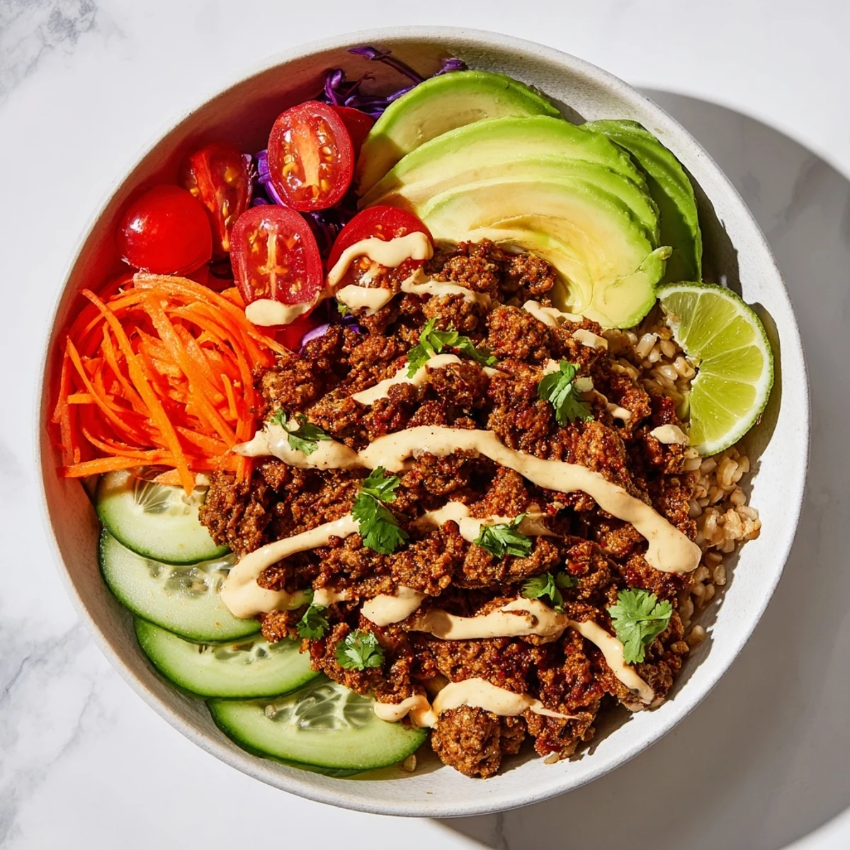 A colorful plant-based meat bowl with fresh veggies and spicy mayo drizzle.  