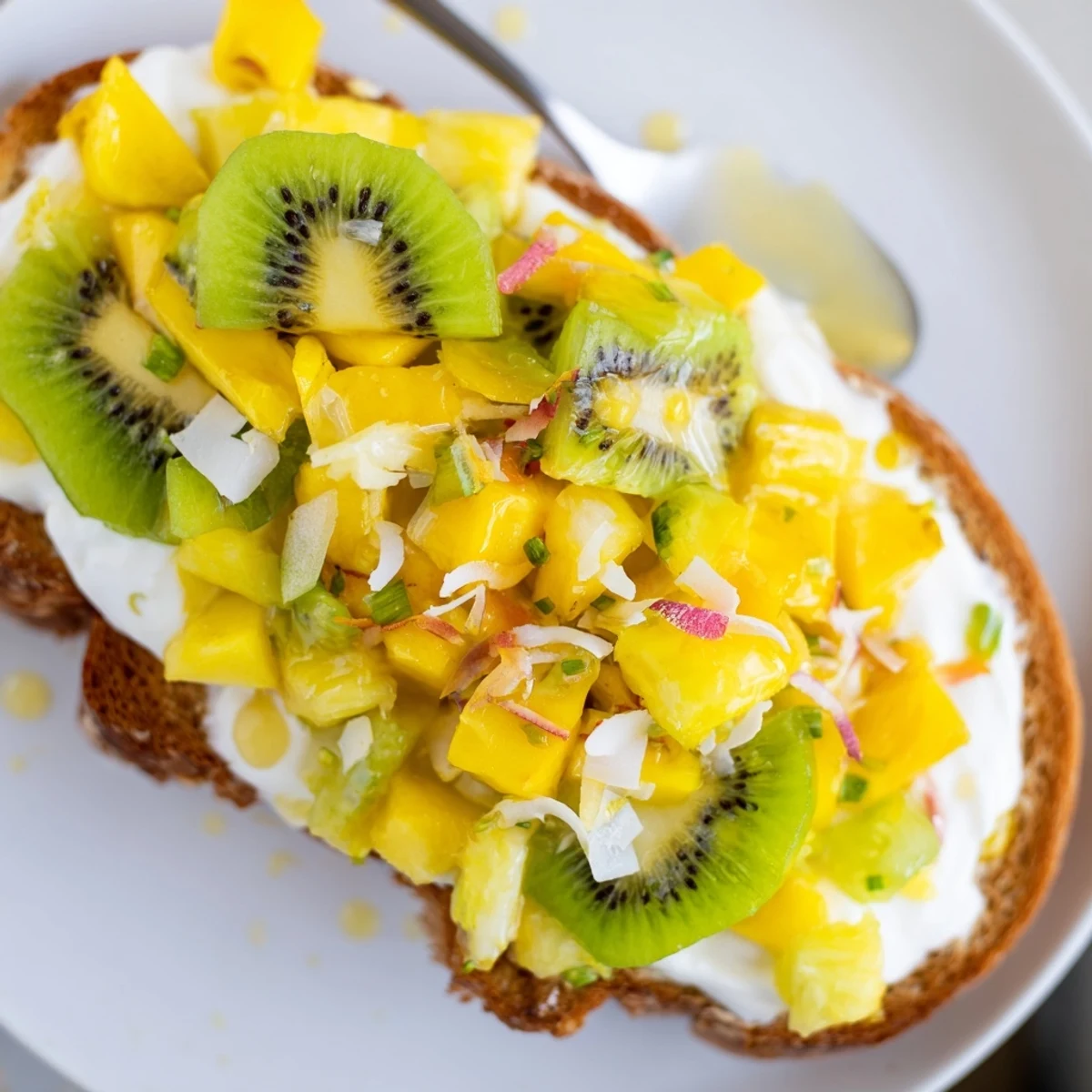 Golden-baked yogurt-custard toast adorned with kiwi and coconut for a tropical twist.