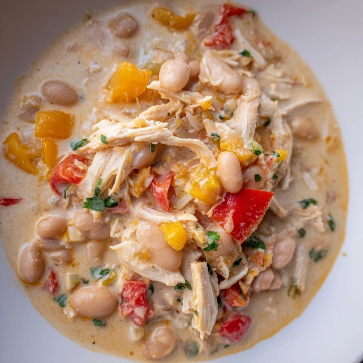 Creamy White Chicken Chili with Beans, a hearty bowl of chili, bursting with savory spices and tender chicken.