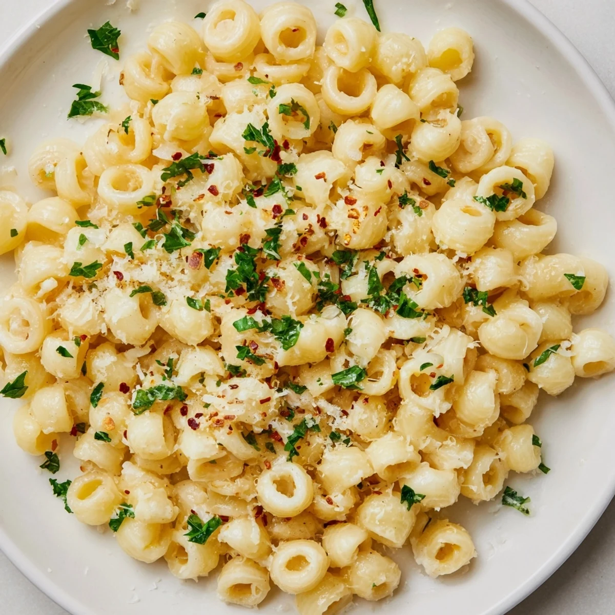 A close-up of steaming ditalini pasta, coated in a rich, creamy garlic sauce, prepared for a quick meal.