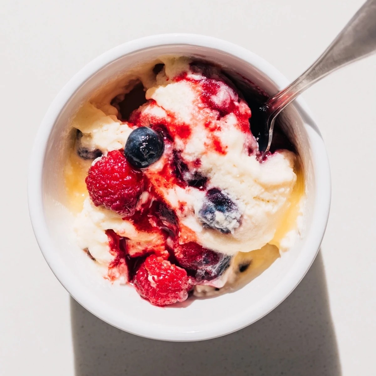 Scoops of homemade cottage cheese ice cream, beautifully pink from blended berries, ready to serve and enjoy.