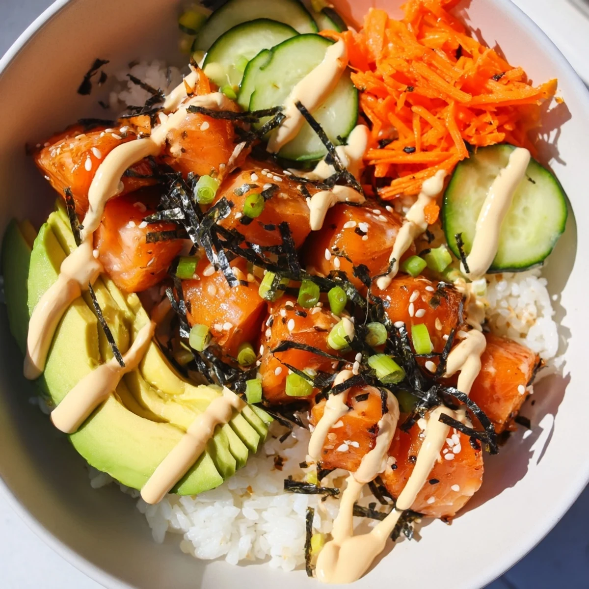 Crispy salmon bites bowl with fresh veggies and creamy sauce, a vibrant culinary delight.
