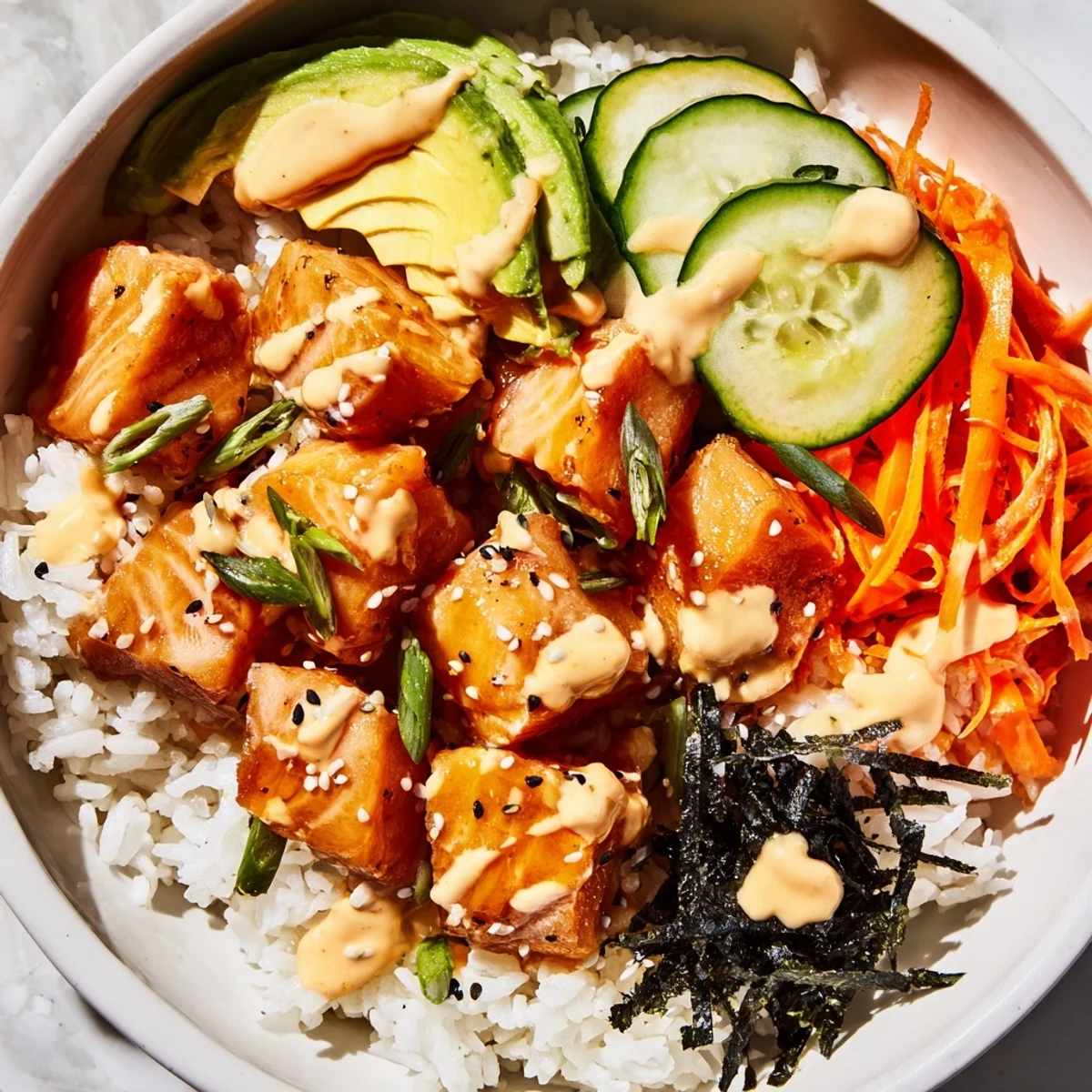Golden salmon bites over jasmine rice in a bowl, a colorful and satisfying fusion dish.