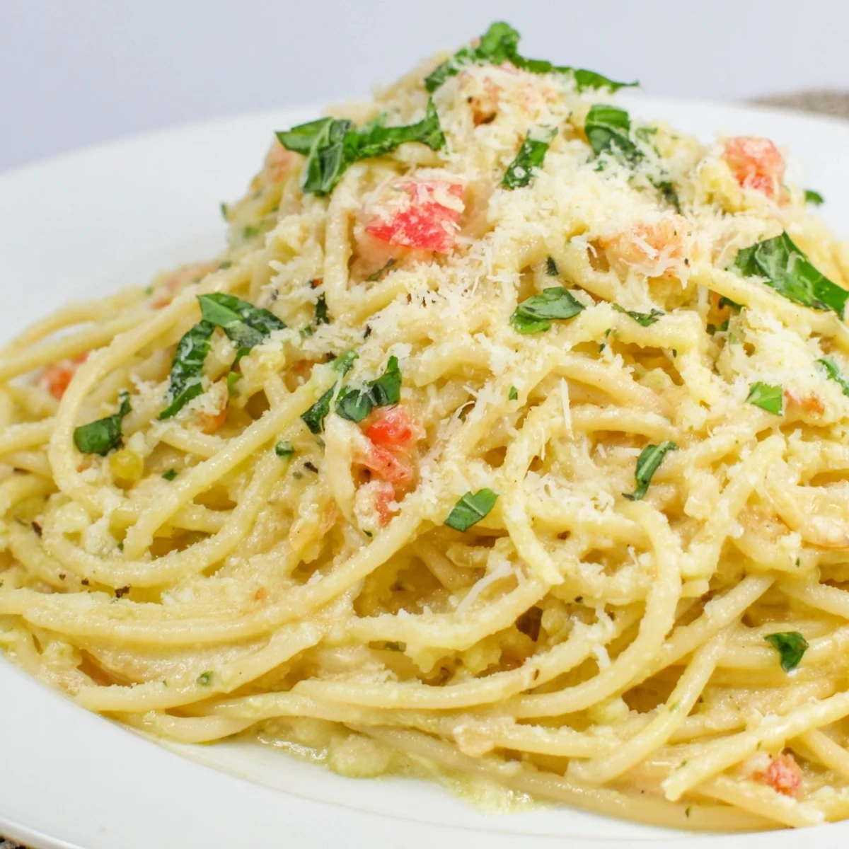 A close-up of a creamy Roasted Garlic Pasta Sauce, invitingly garnished with fresh basil and Parmesan.