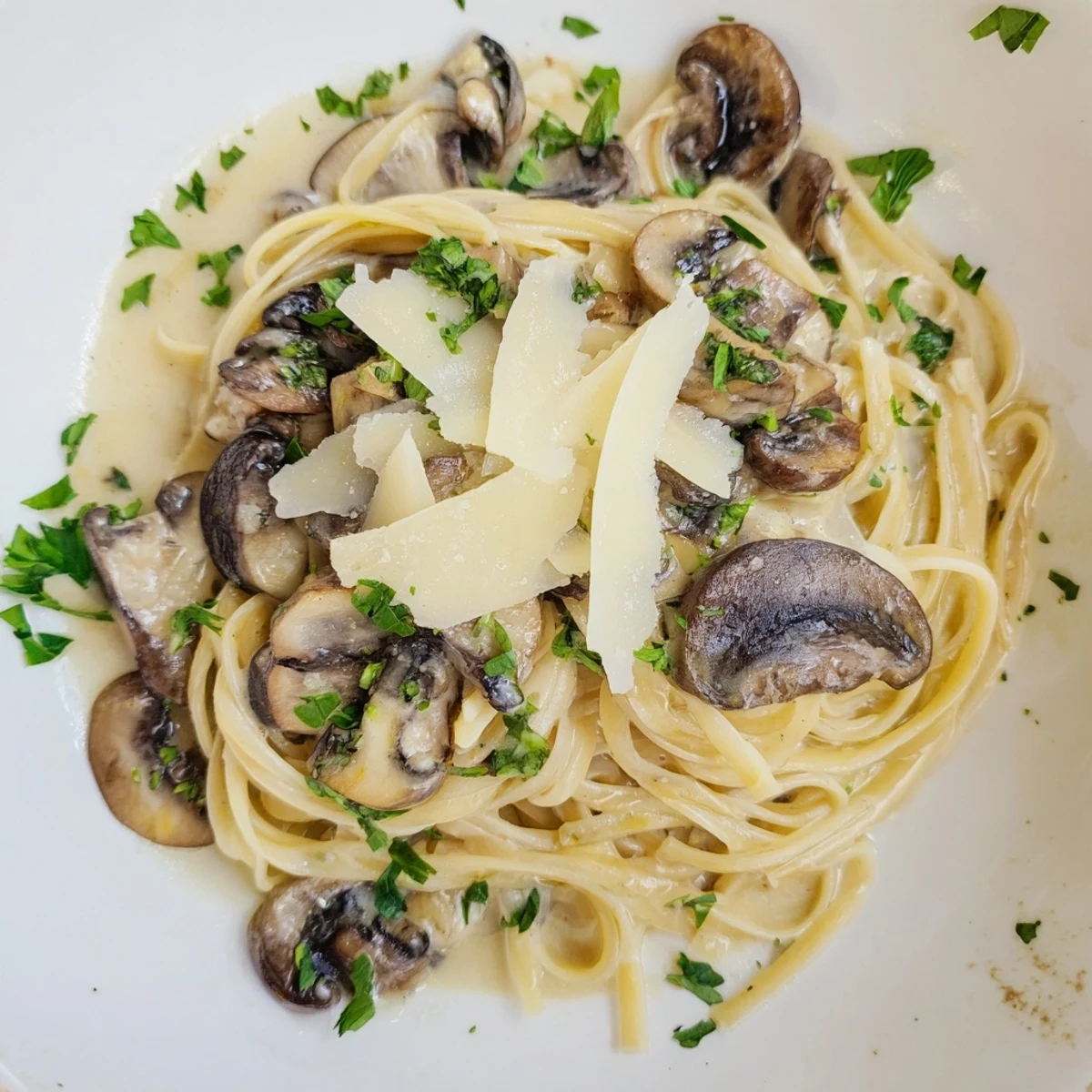 Delicious cream sauce coats the perfectly cooked creamy mushroom linguine, garnished with fresh parsley.