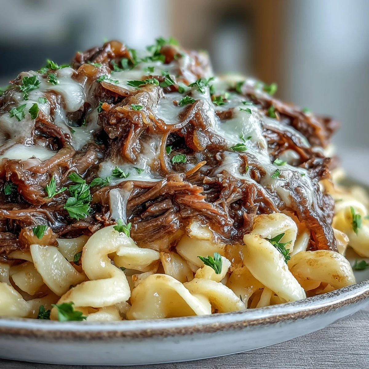 Crockpot French Onion Pot Roast Pasta with tender shredded beef and caramelized onions in rich gravy over egg noodles.