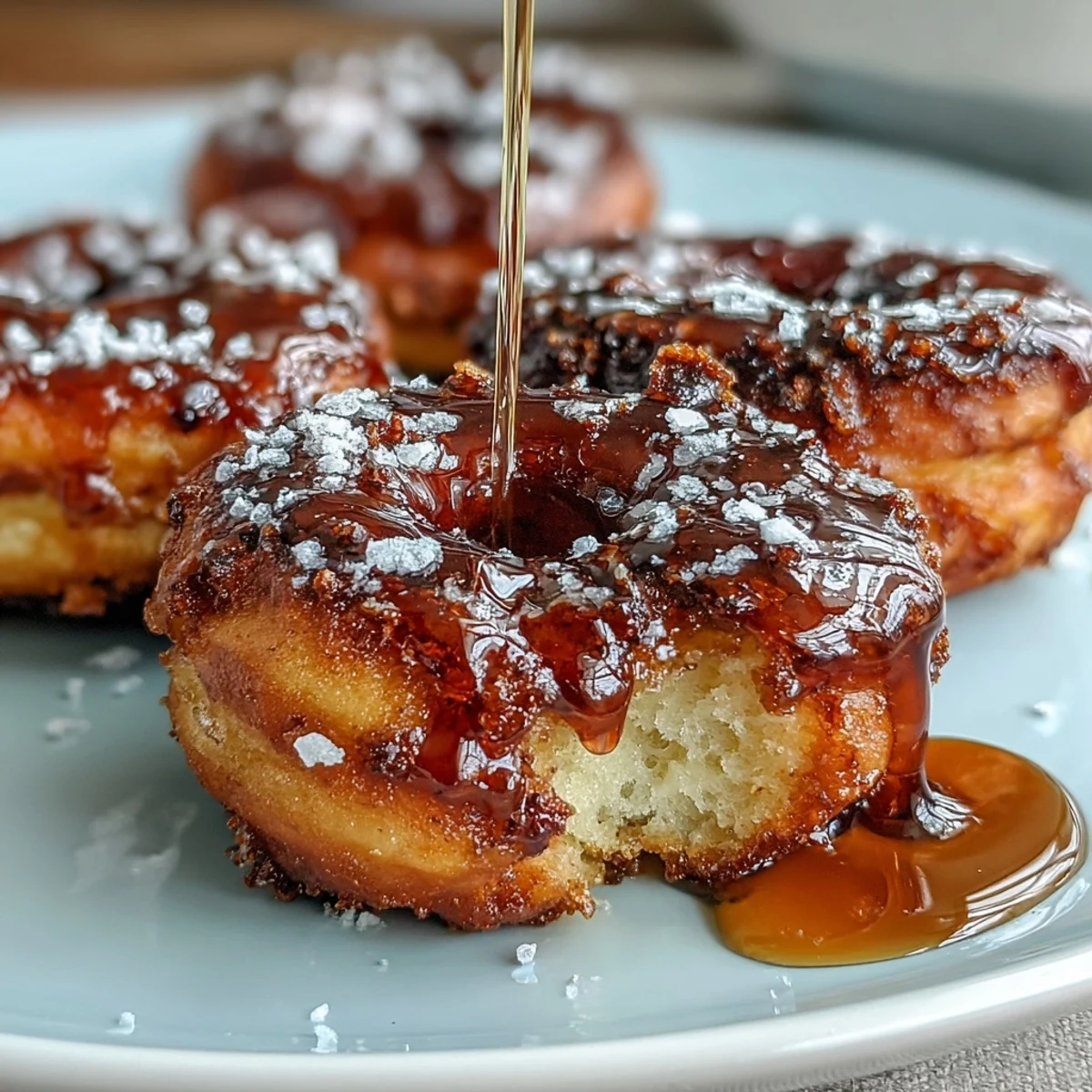 Fluffy cardamom donuts served on a rustic plate, glistening with honey glaze and inviting you to take a bite.