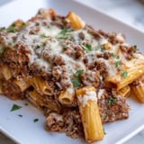 A close-up of cheesy, golden brown baked ziti, a delicious Italian-American family classic.