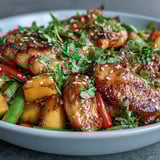 Aromatic chicken stir-fry featuring juicy mango, crisp snap peas, and colorful peppers.  