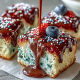 Festive red, white, and blue poke cake with creamy ganache ready for celebration.