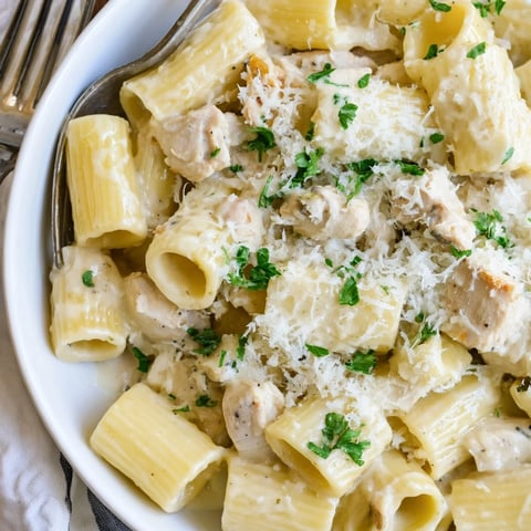 Creamy Garlic Parmesan Chicken Rigatoni drizzled with olive oil and fresh parsley highlights comfort food.