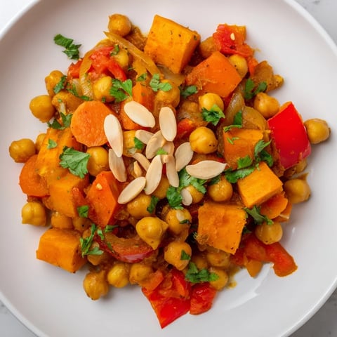 Steaming bowl of Moroccan Chickpea & Sweet Potato Tagine, richly spiced with a vibrant, thick sauce.