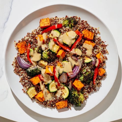 A colorful quinoa bowl with roasted seasonal veggies and creamy lemon-tahini dressing.