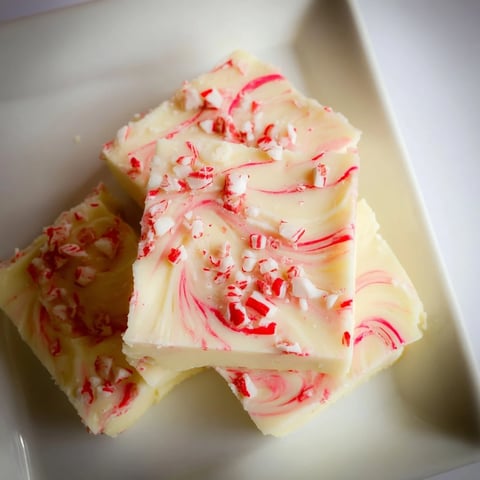Vibrant white chocolate peppermint bark fudge, speckled with crushed candy canes, ready to enjoy.