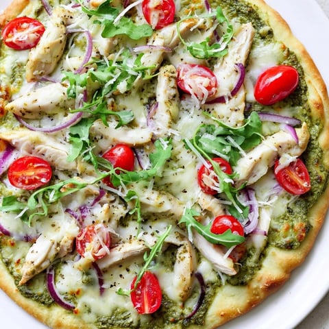 Savory pesto chicken flatbread sizzling with melted mozzarella and ripe cherry tomatoes.