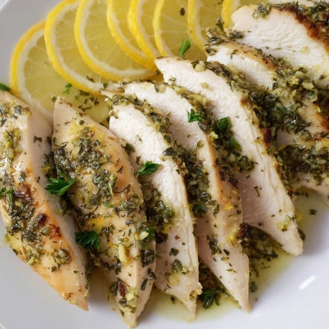 Golden, baked Greek Lemon Herb Chicken, full of vibrant flavor, served with fresh lemon wedges.