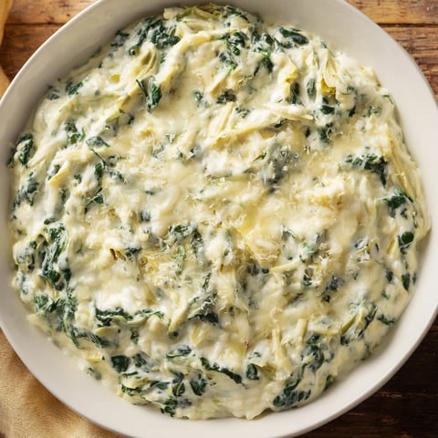 Warm, bubbly Cheesy Spinach Artichoke Dip, fresh from the oven, ready to serve with crispy tortilla chips.