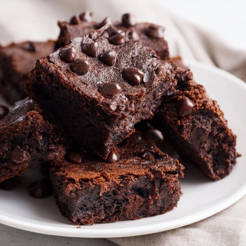 Close-up of freshly baked Greek yogurt brownies, fudgy texture with visible chocolate chips, ready to eat.