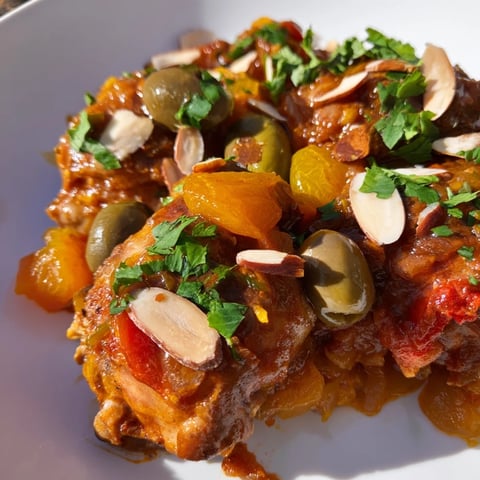 Golden brown Moroccan Tagine Chicken with tender apricots, olives, and a rich, spiced sauce.