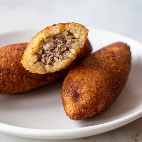 Golden-brown Lebanese Kibbeh, with a savory, spiced meat filling, ready to serve with yogurt.