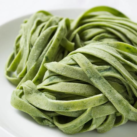 Vibrant green spinach pasta dough, ready to be rolled and cut into perfect pasta shapes.