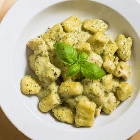 Golden pan-crisped gnocchi and juicy chicken bites are coated in a vibrant basil pesto cream sauce for a comforting Italian-inspired weeknight dinner.  