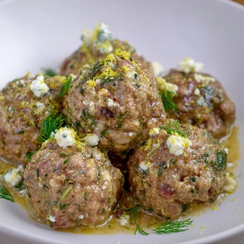 Instant Pot Greek Meatballs, glistening in a vibrant tomato sauce, topped with creamy lemon-feta.