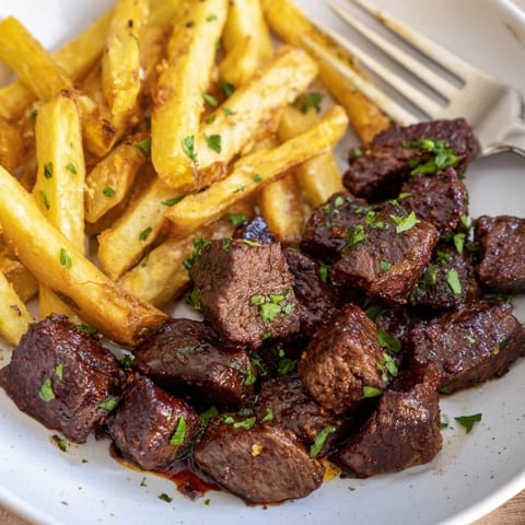 Spicy Blackened Cajun Steak Bites with golden fries, perfect for game day feasts.  