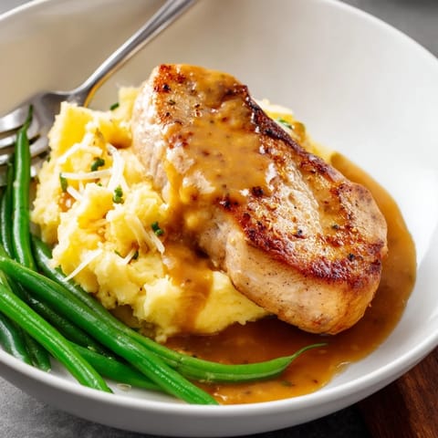 Comforting Pork Chops & Cheddar Mash Bowl garnished with green beans for a satisfying meal.  