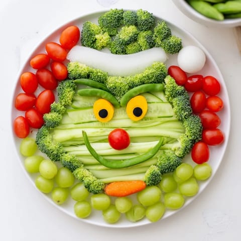 Festive Savory Crudités Grinch Face: A fun, edible veggie platter with colorful Grinch's facial features.