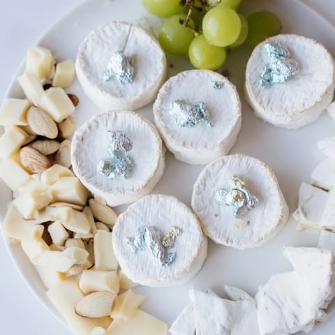 An inviting Winter Wonderland Platter offers a delightful spread of cheeses, fruits, and sugared almonds.
