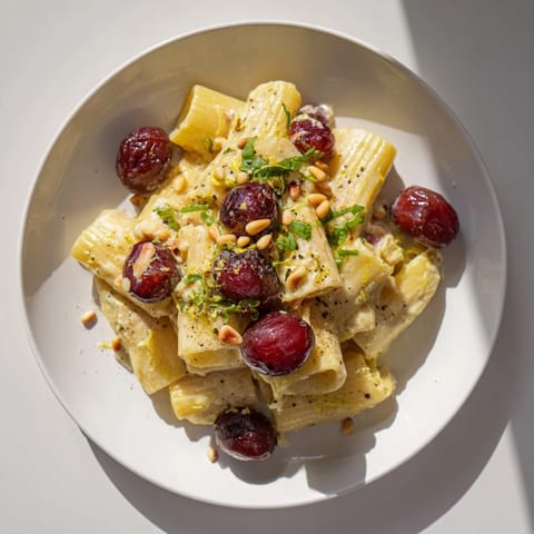 Close-up of the Pasta with Roasted Grapes, featuring blistered grapes with fresh ricotta and herbs.