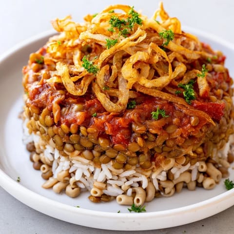 Golden, crispy fried onions top a flavorful plate of homemade Egyptian Koshari, a vegan delight.
