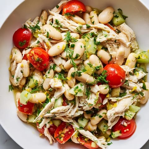 A close-up view of Lemony White Bean Chicken Salad in a white bowl, perfect for a light, high-protein lunch.