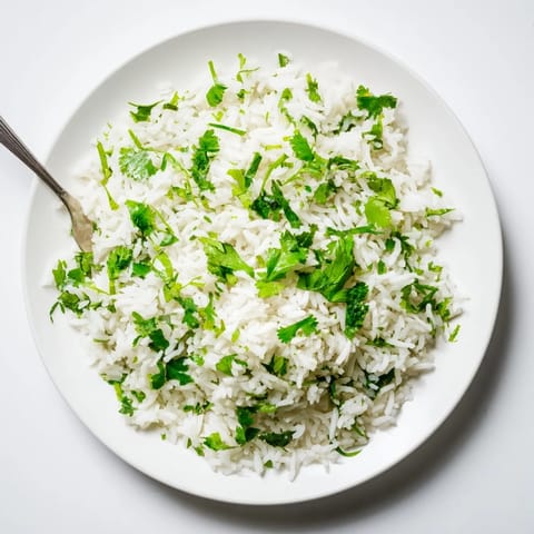 A steaming pot of cilantro lime rice with fresh herbs and citrus, ready to accompany tacos or grilled meats.