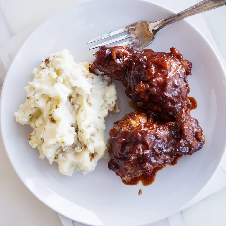Flavorful honey BBQ chicken thighs alongside velvety garlic mashed potatoes for dinner.