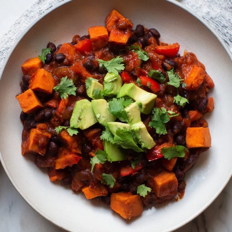Homemade Sweet Potato & Black Bean Chili simmering in a pot, releasing warming spice aromas.