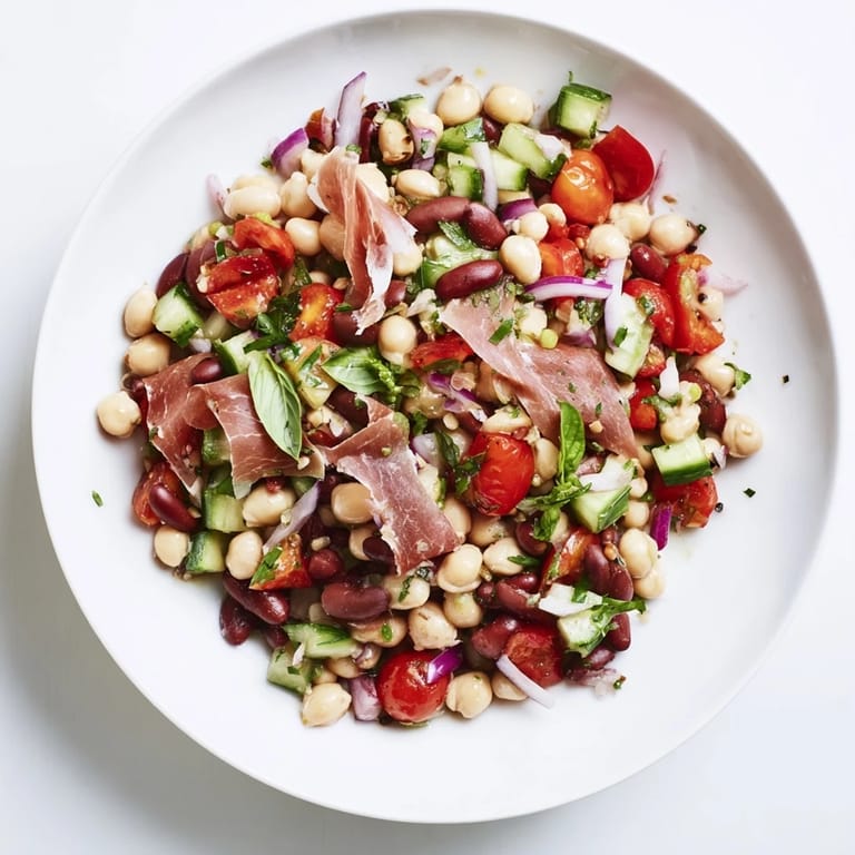 A close-up of the flavorful Dense Bean Salad with Prosciutto, showcasing vibrant vegetables and salty prosciutto.