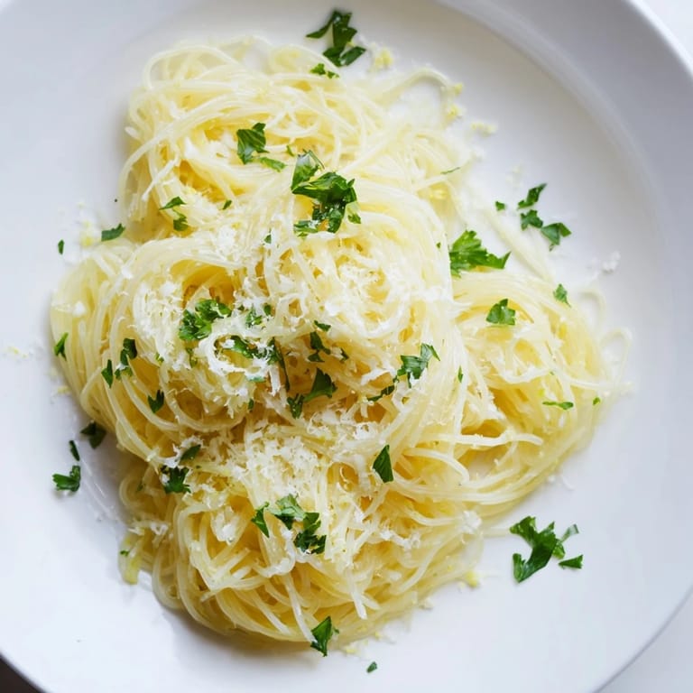 Close-up of freshly made Lemon Butter Pasta Light topped with Parmesan and bright parsley.
