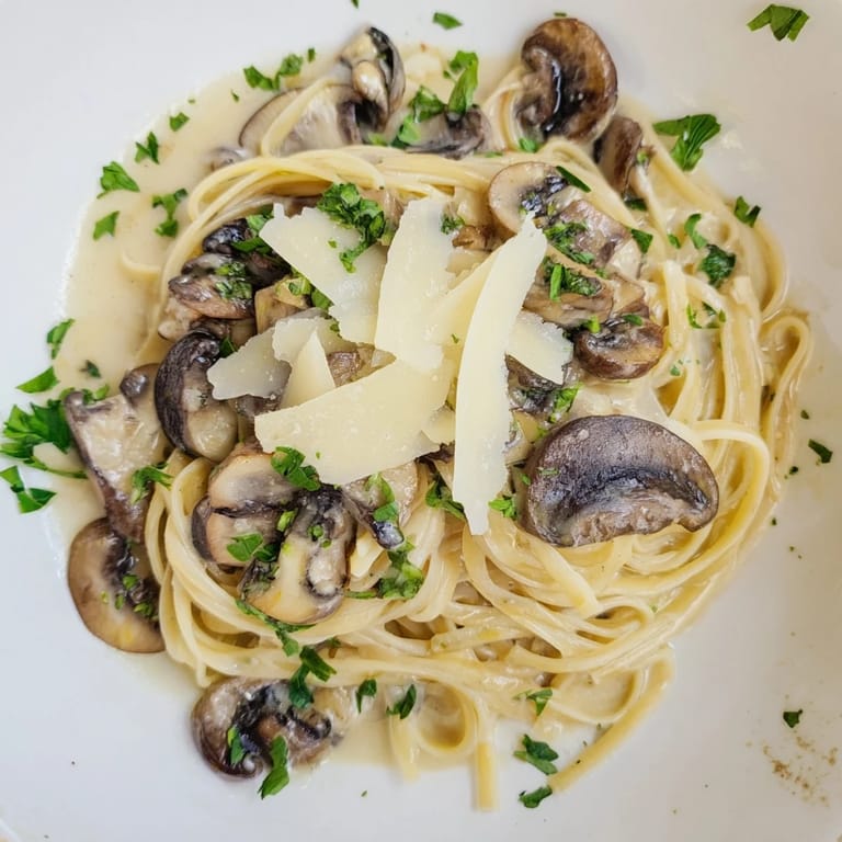 Delicious cream sauce coats the perfectly cooked creamy mushroom linguine, garnished with fresh parsley.