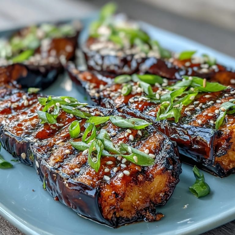 Sweet and savory miso-glazed eggplant, roasted until tender and bubbling, garnished with sesame seeds and green onions.