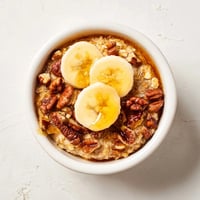 Golden-brown Baked Oats Ramekins with banana slices and a lovely honey drizzle.