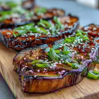 Roasted eggplant halves glazed with sweet and savory miso, caramelized to perfection for an umami-rich vegetarian dish.